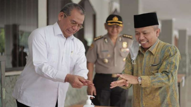 Direktur Bina Haji Khoiri dan Direktur Jenderal Penyelenggaraan Haji dan Umrah Nizar mencuci tangan sebelum memasuki ruang tes calon petugas haji di Asrama Haji, Pondok gede, Jakarta, Rabu, 18 Maret 2020.