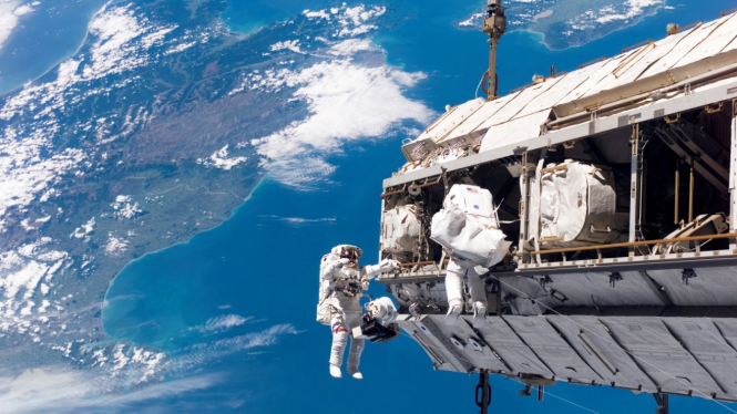 Astronot bekerja di luar Stasiun Luar Angkasa Internasional (ISS).