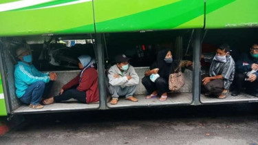 Penumpang rela duduk di bagasi bus demi bisa mudik