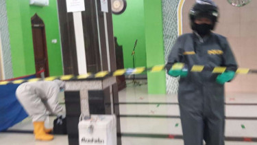 Petugas polisi berpakaian hazmat memeriksa dan mengevakuasi jenazah seorang jemaah masjid yang meninggal dunia secara mendadak usai salat subuh di Kota Bekasi, Jawa Barat, Rabu, 29 April 2020.