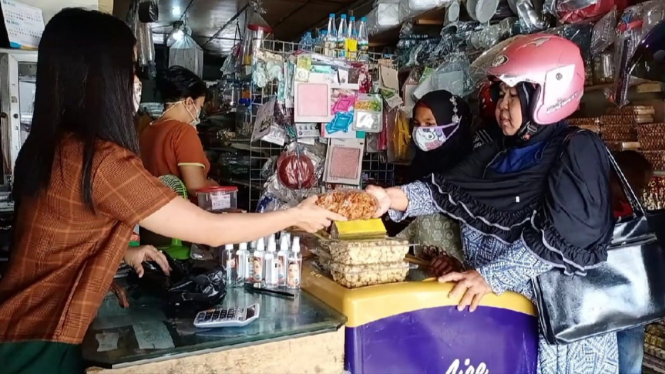 Nurmadiah dan anaknya sedang berbelanja kue lebaran.[Suarakalbar/Tambong]