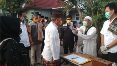 Jemaah melakukan pengukuran suhu tubuh sebelum masuk masjid di tengah pandemi COVID-19