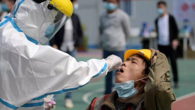 Petugas medis di Wuhan sedang mengambil swab test dari warga. 
