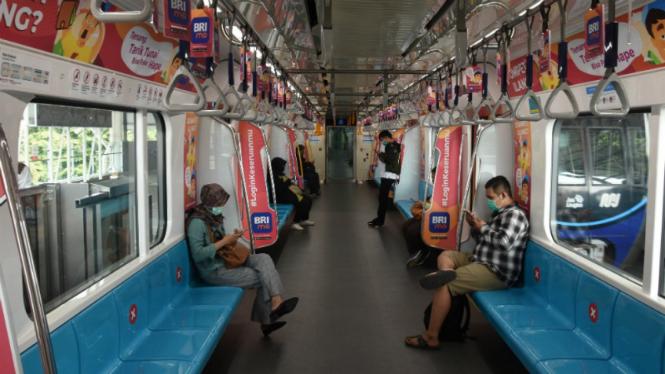 Penumpang duduk dengan menjaga jarak di dalam kereta MRT