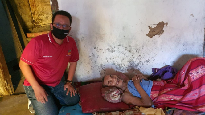 Seorang kakek bernama Jahrani yang tergolek sakit di kasur. (kanan) 
