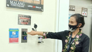 Petugas manajemen Malang Town Square menunjukkan sensor digital untuk menekan tombol lift sebagai bagian dari prosedur pencegahan penularan Covid-19.