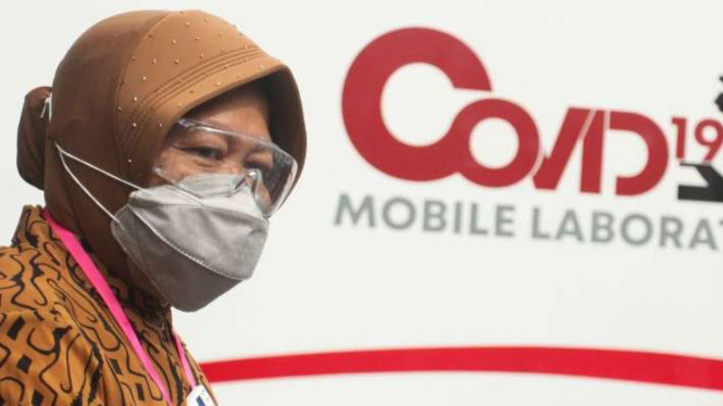 Wali Kota Surabaya Tri Rismaharini berjalan di dekat mobil laboratorium COVID-19 saat tes cepat (Rapid Test) COVID-19 massal di Lapangan Hoki, Jalan Dharmawangsa, Surabaya, Jawa Timur, Sabtu (20/6/2020). 