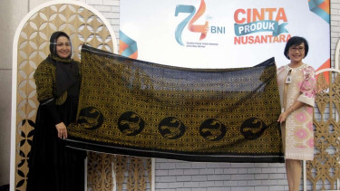 Direktur Bisnis UMKM BNI Tambok P Setyawati (Kanan) dan Pemilik Tenun Puta Dino Kayangan Anita Gathmir (Kiri) menunjukkan kain tanda apresiasi dari Kesultanan Tidore pada Show Case Cinta Produk Nusantara di Lobi Grha BNI, Jakarta, Senin (6/7) 2020.