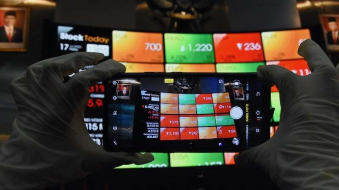 Karyawan mengambil gambar layar pergerakan harga saham (IHSG) di gedung Bursa Efek Indonesia, Jakarta. (Foto ilustrasi)