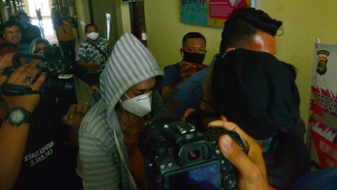 Personel kepolisian membawa artis berinisial VS (tengah) saat akan menjalani pemeriksaan di Polresta Bandar Lampung, Lampung, Rabu (29/7/2020). 