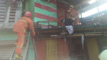 Petugas tengah memadamkan api yang membakar rumah di Kalideres, Jakarta.