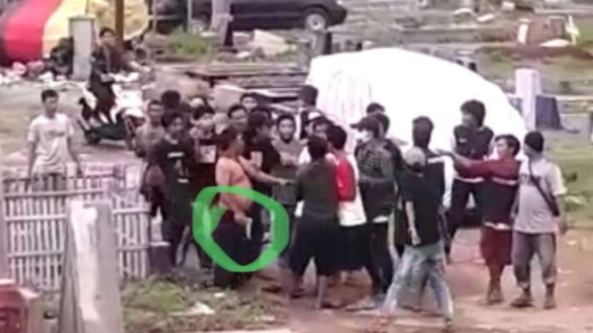 Pria menenteng senpi di TPU Menteng Pulo di lingkar hijau.