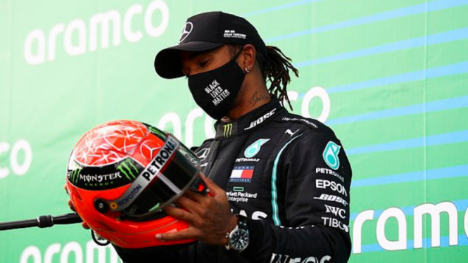 Pembalap Mercedes, Lewis Hamilton, menerima helm keramat Michael Schumacher