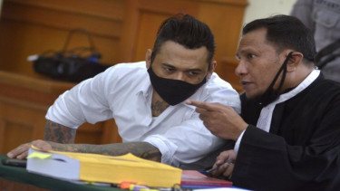 Drummer SID I Gede Ari Astina alias Jerinx (kiri) berbincang dengan pengacaranya