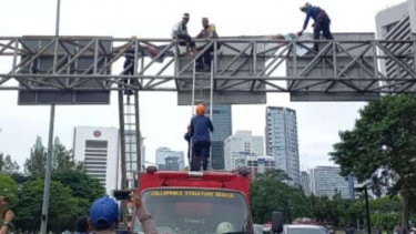 Aksi Agustinus Worowuli yang kembali naik ke atas tower rambu lalu lintas.