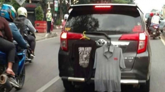 Ada dua kaos menggantung di wiper belakang Toyota Calya