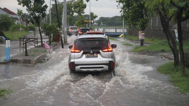 Ilustrasi kendaraan menerabas jalanan yang banjir