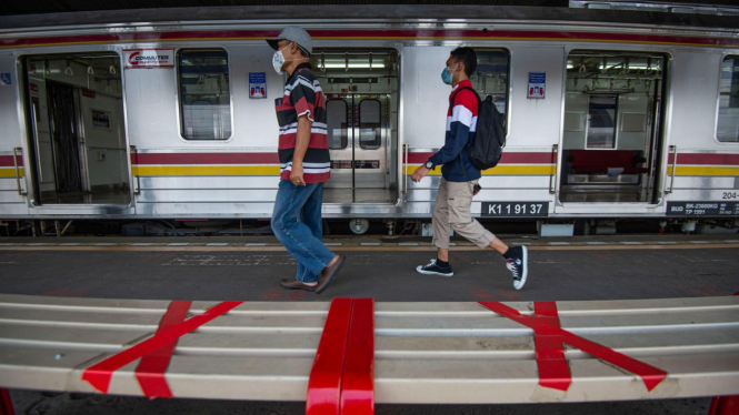 Penumpang Kereta Commuter Line saat berhenti di stasiun.