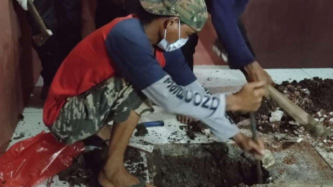 Polisi dibantu beberapa warga berhasil mengevakuasi sesosok jasad yang dikubur di dalam rumah kontrakan di kawasan Gang Kopral Daman, Kecamatan Sawangan, Depok, Jawa Barat. 