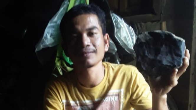 Josua Hutagalung menunjukkan batu meteor yang menimpa rumahnya.-DOK.PRIBADI