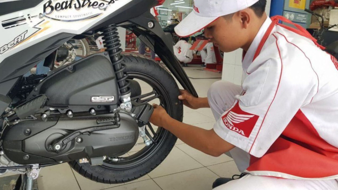 Mekanik memeriksa ban motor