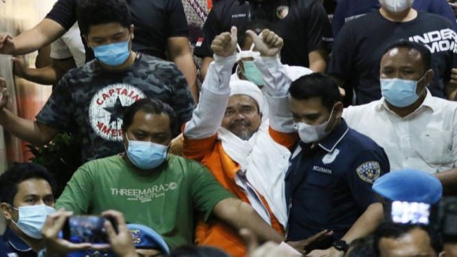 Imam Besar Habib Muhammad Rizieq Shihab mengenakan baju tahanan dan diborgol usai pemeriksaan.