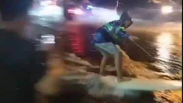 Warga Bali main selancar di jalanan yang tergenang banjir.