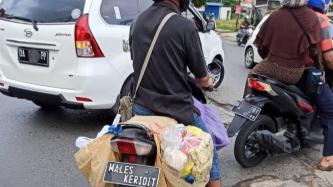 Plat nomor Males Keridit di sepeda motor bebek.