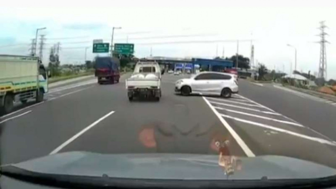 Mobil Datsun tertangkap kamera dasbor sedang putar balik di jalan tol.