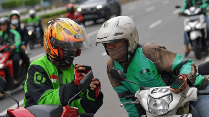 Ilustrasi dua orang pengemudi ojek online berbincang di Jalan (ANTARA /M Risyal Hidayat).