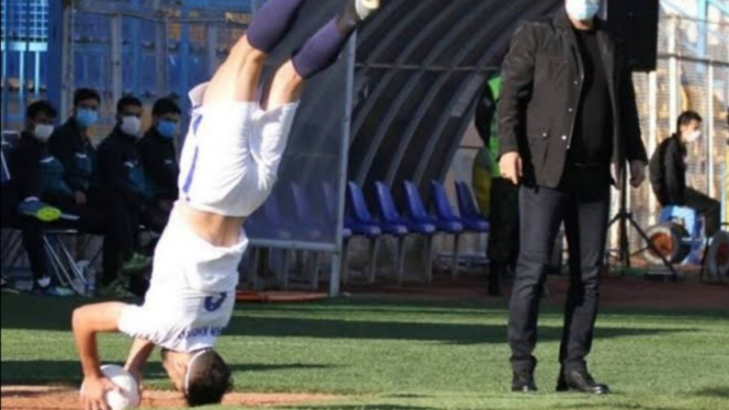 Pemain asal Iran, Nader Mohammadi, melakukan lemparan ke dalam sambil salto. 
