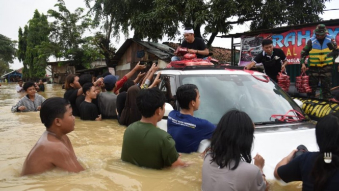 Anggota DPR RI Dedi Mulyadi membagikan nasi kotak korban banjir di Karawang