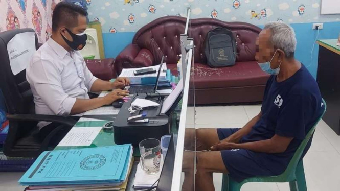 Polisi saat memeriksa kakek cabul di Sumut.