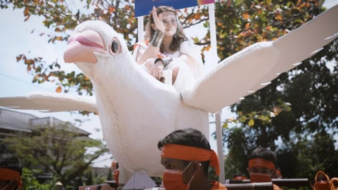 Jovita Karen antar paket naik merpati raksasa.
