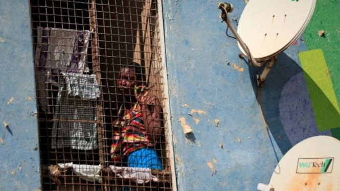 Seorang wanita melihat dari blok apartemen di hari pertama penguncian (lockdown) 21 hari di seluruh negeri untuk menekan laju penularan COVID-19 di Harare, Zimbabwe, Senin, 30 Maret 2020.