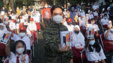 Wali Kota Solo Gibran Rakabuming Raka menyerahkan bantuan 150 unit ponsel pintar kepada para siswa SD dan SMP terutama bagi mereka yang tidak memiliki ponsel untuk kegiatan pembelajaran jarak jauh pada Jumat, 12 Maret 2021.