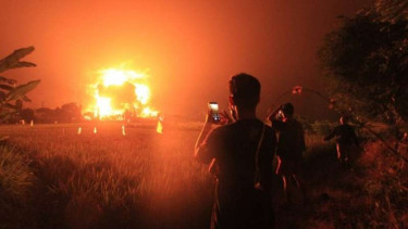 Warga menyaksikan kebakaran yang terjadi di kompleks kilang Pertamina RU VI Balongan, Indramayu, Jawa Barat, Senin dini hari, 29 Maret 2021.