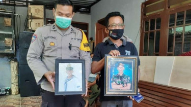 Sunaryo, ayah Fajar awak KRI Nanggala 402 pegang foto Fajar (kanan)