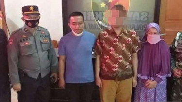 Seorang pria berinisial HH pemilik akun Facebook "Kholip Ajaw" (menggunakan kemeja batik), terduga penghina TNI dan kru kapal selam KRI Nanggala-402, didampingi keluarganya di markas Polres Sukabumi, Sabtu, 1 Mei 2021.