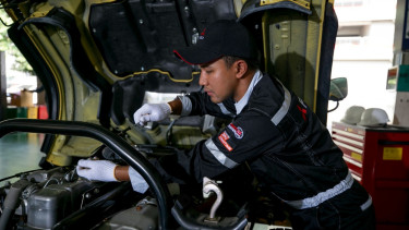 Mekanik memperbaiki truk Fuso