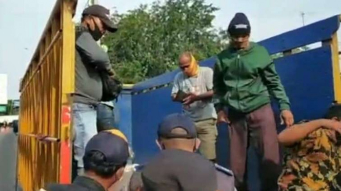 Pemudik mengumpet di bak truk di Bekasi.