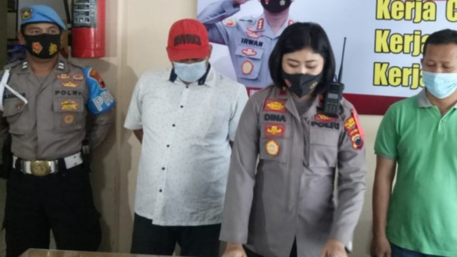 Polisi mengamankan pelaku pemalsu swab test (bertopi merah)