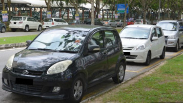 Parkir mobil pinggir jalan di Kuala Lumpur.