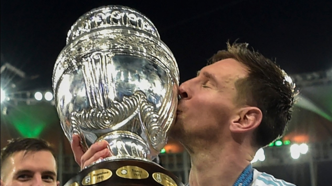 Megabintang Timnas Argentina, Lionel Messi, mencium trofi Copa America. 