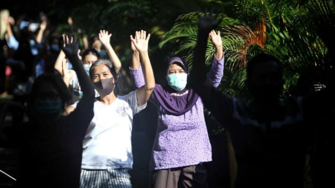 Sejumlah pasien COVID-19 yang terkategori ringan alias orang tanpa gejala (OTG) bersenam pagi di kompleks karantina terpusat yang disediakan oleh Pemerintah Kota Solo di gedung SDN Cemara 2, Kamis, 15 Juli 2021.