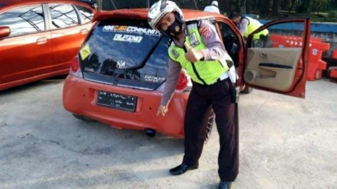 Polisi menilang mobil yang menggunakan knalpot bising.