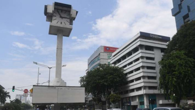 Sejumlah kendaraan melintasi Tugu Jam Thamrin di Jakarta.