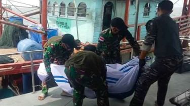 Petugas melakukan evakuasi jenazah korban kapal terbakar.