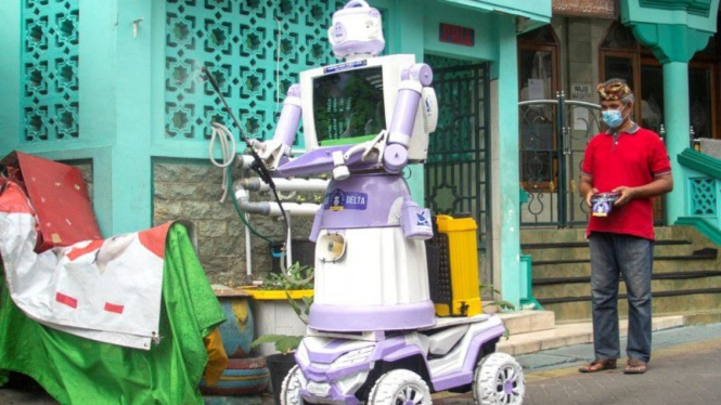 Aseyanto, warga Tembok Gede, mengoperasikan "Robot Delta", yang terbuat dari barang-barang rumah tangga bekas seperti panci, wajan, dan monitor televisi tua, di Surabaya, Jawa Timur, Indonesia (07/08/2021). (Supplied:Â REUTERS/Prasto Wardoyo)