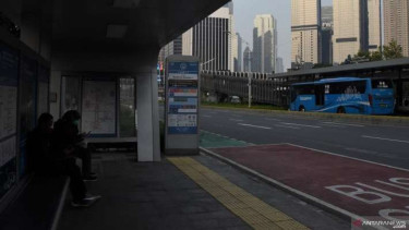Calon penumpang menunggu bus TransJakarta di Halte Bundaran Senayan 2, Jakarta.